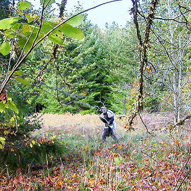 Jerry Austin crosses a field at Maple Hill Cemetery, Lebam, Pacific County, Washington