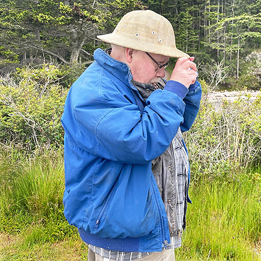 Rod Crawford examines a spider, Reuben Tarte County Park, San Juan Island, Washington