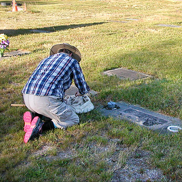 Laurel Ramseyer collecting spiders from vases, Evergreen Cemetery, Packwood, Washington