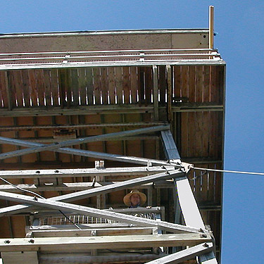 Laurel Ramseyer looks down from lookout tower, North Mountain, Skagit County, Washington (nr Darrington)